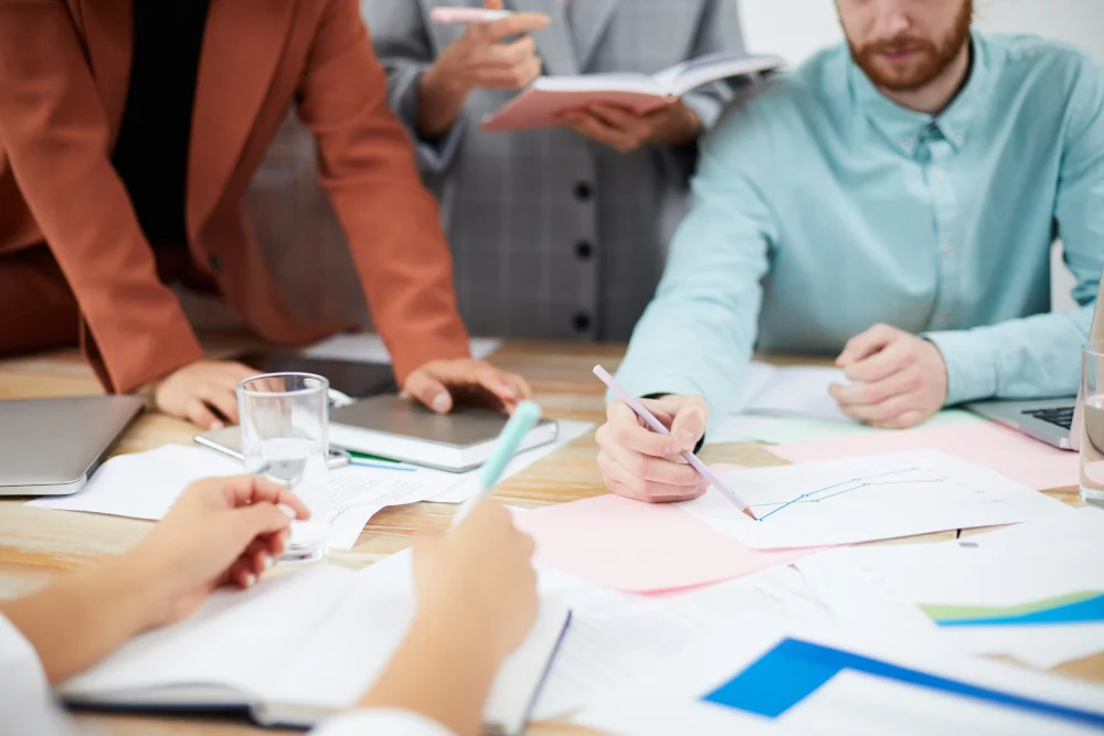 People discussing plans around a table